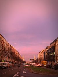 Road in city against sky at sunset