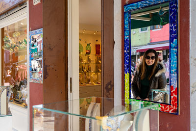 Portrait of smiling young woman standing in store