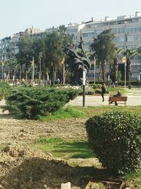 People in park against buildings in city