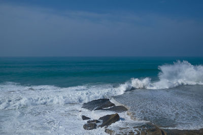 Scenic view of sea and waves against sky