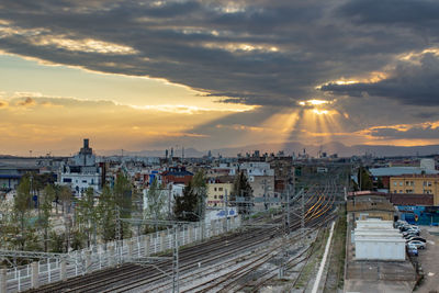 High angle view of railroad tracks against buildings during sunset