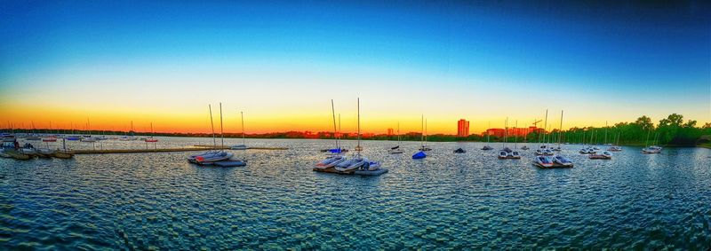 Boats in calm sea at sunset