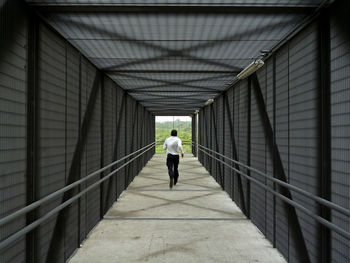 Rear view of man walking on footpath