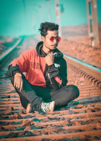 Portrait of young man sitting on land