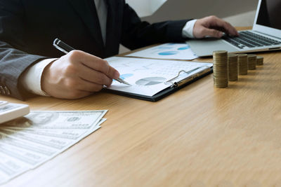 Midsection of man using mobile phone on table