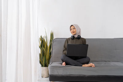 Portrait of woman using laptop at home