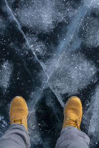 Low section of man standing on ice