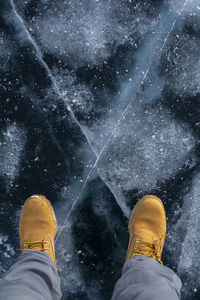 Low section of man standing on snow