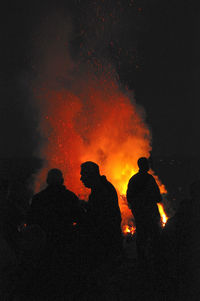 Silhouette people against fire at night