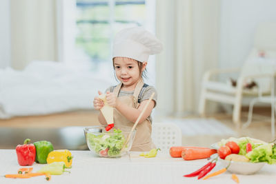 Portrait of smiling woman with vegetables in kitchen