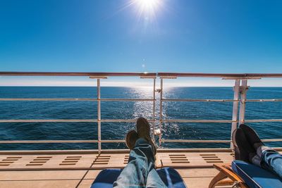 Rear view of people relaxing on boat sailing in sea