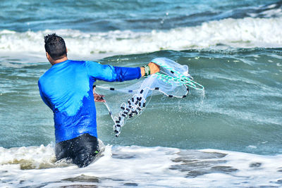 Rear view of man surfing in sea