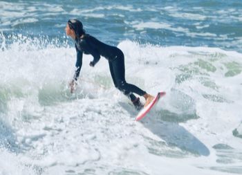 Full length of man splashing water in sea