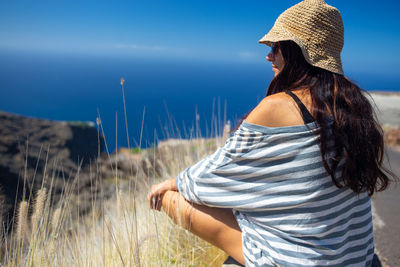 Rear view of woman sitting outdoors