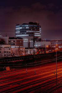 Illuminated cityscape against sky at night