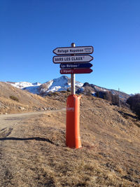 Information sign on landscape against clear blue sky
