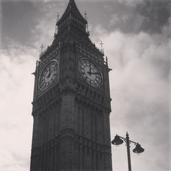 Low angle view of clock tower against cloudy sky