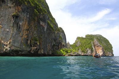 Scenic view of rock formation in sea against sky