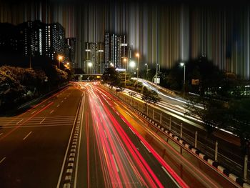 High angle view of light trails on street amidst buildings at night