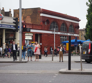 People walking on road against buildings in city