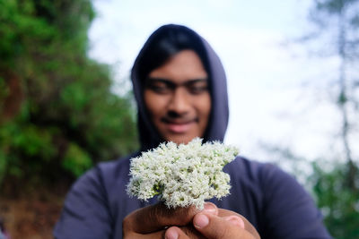 Close-up of beautiful young woman holding flower