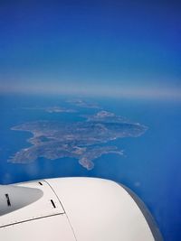 Airplane flying over sea against blue sky