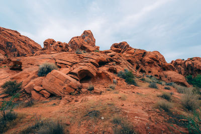 Rock formations on landscape against cloudy sky