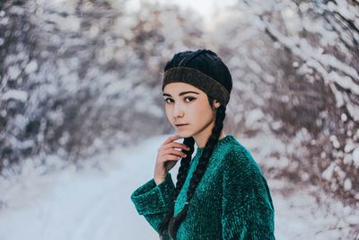Portrait of young woman standing in snow
