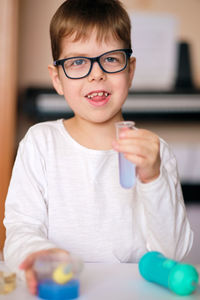 Boy is engaged in scientific research. a child with a test tube and a pipette in his hands. 