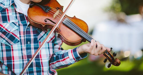 Midsection of man playing violin