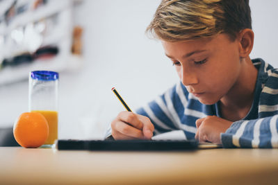 Close-up of boy studying at home