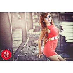 Portrait of young woman standing against red umbrella