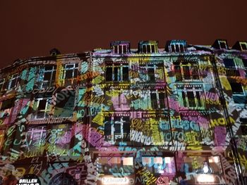 Low angle view of illuminated lights against sky at night