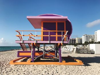 Lifeguard hut on beach against sky on sunny day