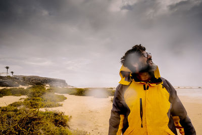 Rear view of woman standing on mountain against sky