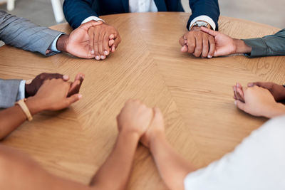 Cropped hands of man with jigsaw puzzle on table