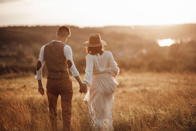 Rear view of man with umbrella on field
