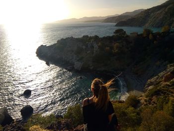 Rear view of woman looking at sea against sky