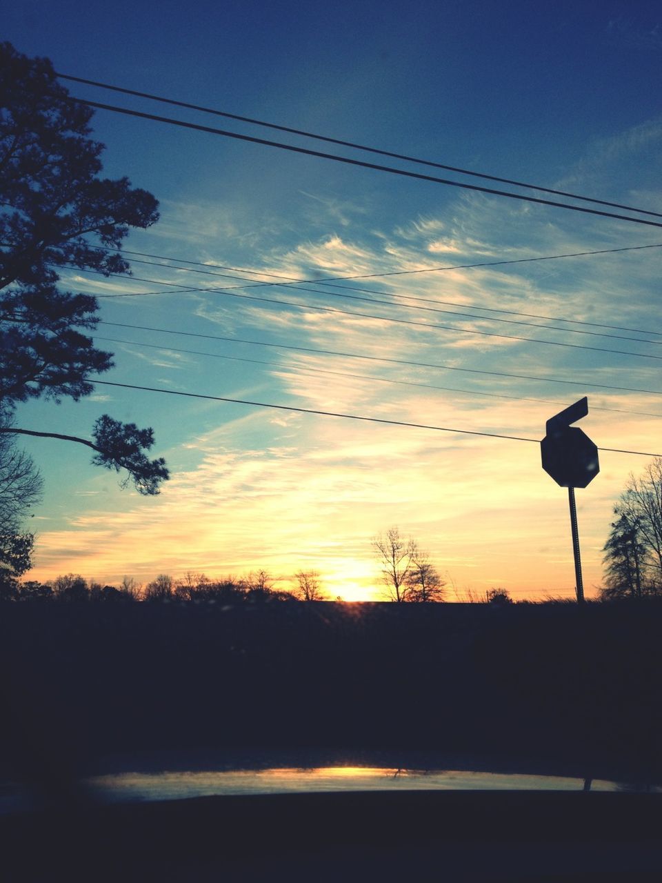 sunset, silhouette, sky, power line, tranquility, scenics, tranquil scene, electricity pylon, tree, beauty in nature, electricity, nature, cable, power supply, landscape, orange color, cloud - sky, street light, dusk, idyllic