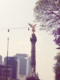 Low angle view of statue against buildings in city