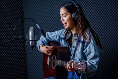 Full length of a woman playing guitar