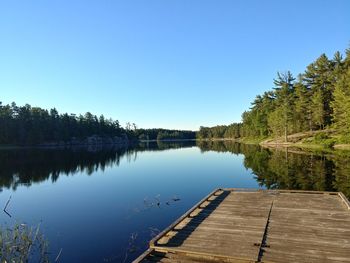 Scenic view of lake against clear blue sky