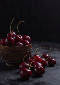 Organic juicy cherry in a bowl on dark background. close-up photo, low key