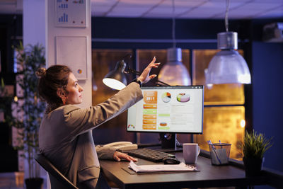 Side view of man using laptop at office