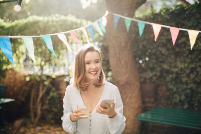 Young woman looking away while standing outdoors