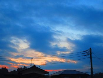 Silhouette electricity pylon against sky during sunset