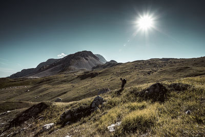 Scenic view of field and mountains against sky