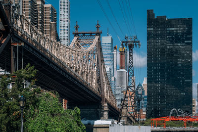 Low angle view of bridge and buildings against sky