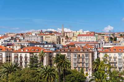 Buildings in city against blue sky