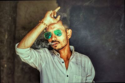 Young man wearing sunglasses smoking